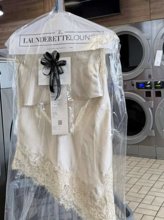Finished dry-cleaned garment in Launderette Lounge packaging with a black ribbon
