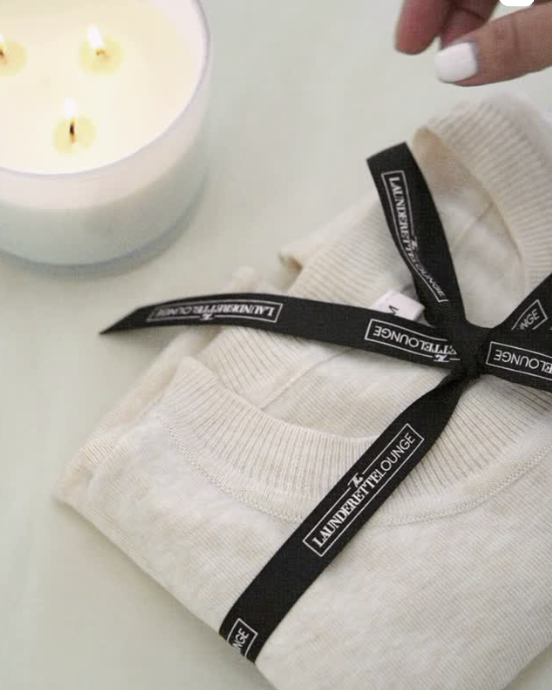 Neatly folded laundry stack tied with a black satin ribbon